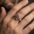 Load image into Gallery viewer, Rose gold plated Celtic windflower ring on a finger, lifestyle shot focusing on the floral rosette centerpiece and dimensional Celtic knotwork