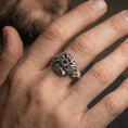 Load image into Gallery viewer, Oxidized Celtic windflower ring worn on a finger, lifestyle close-up showing the darkened openwork flower rosette and Celtic knot petals