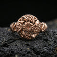 Load image into Gallery viewer, Rose gold plated Celtic windflower ring with floral rosette centerpiece and interwoven knot petals, close-up product shot on volcanic rock
