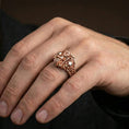 Load image into Gallery viewer, Rose gold plated biker ring on the finger featuring twin skulls and motorcycle handlebar design, lifestyle shot with strong metal depth