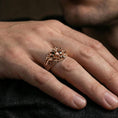 Load image into Gallery viewer, Rose gold plated skull ring on the finger, lifestyle shot showcasing the spiked crown design and chain-patterned sides