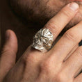 Load image into Gallery viewer, Polished silver cyber skull ring on the finger, wearable close-up focusing on the mechanical linework and deep eye sockets