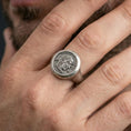 Load image into Gallery viewer, Oxidized Greek coin signet ring worn on a finger, close-up lifestyle shot highlighting the coin portrait relief
