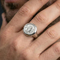 Load image into Gallery viewer, Polished silver Greek coin ring on the finger, wearable close-up focusing on the raised classical profile and signet shape
