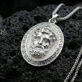Load image into Gallery viewer, Polished silver Medusa medallion necklace on volcanic rock, crisp relief portrait and meander frame detail, close-up