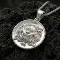 Load image into Gallery viewer, Polished silver guardian lion medallion necklace on volcanic rock, crisp sculpted face and textured background, close-up