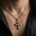 Load image into Gallery viewer, Rose gold plated winged ankh cross necklace worn on neck, lifestyle wear shot, warm plating tone and sculpted depth