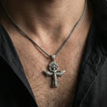 Load image into Gallery viewer, Oxidized Egyptian winged ankh cross necklace worn on neck, lifestyle close-up, pendant centered with braided chain
