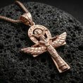 Load image into Gallery viewer, Rose gold plated winged ankh cross pendant on volcanic rock, textured lava stone background, detailed engravings and wings