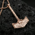Load image into Gallery viewer, Rose gold plated Thor hammer pendant on volcanic rock, textured lava stone background, ornate Norse rune and rope detail