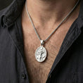 Load image into Gallery viewer, Polished silver Hela pendant necklace worn on neck, clean lifestyle framing, reflective finish and sharp engraved details