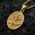 Load image into Gallery viewer, Gold plated Hela pendant on volcanic rock, premium studio scene, Norse myth medallion necklace design