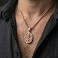 Load image into Gallery viewer, Rose gold plated Hela pendant necklace worn on neck, lifestyle wear shot, warm plating tone and sculpted relief depth