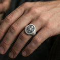 Load image into Gallery viewer, Oxidized octopus signet ring worn on finger, lifestyle close-up, nautical sea creature statement ring with raised emblem detail