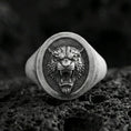 Load image into Gallery viewer, Oxidized sterling silver tiger signet ring on volcanic rock, oval face with roaring tiger head relief and dark textured background, macro product photo