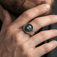 Load image into Gallery viewer, Oxidized wolf octagon signet ring worn on finger, lifestyle close-up, wolf head relief centered on octagonal face