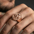 Load image into Gallery viewer, Rose gold plated shield octopus signet ring worn on finger, lifestyle wear shot showcasing shield crest face and detailed octopus tentacle motif