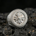 Load image into Gallery viewer, Polished silver rosette signet ring featuring a sculpted flower centerpiece and twisted rope frame, product close-up on volcanic stone