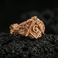 Load image into Gallery viewer, Rose gold plated Freemason square and compass ring with “G” emblem and carved ornamental band, macro shot on volcanic rock