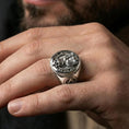 Load image into Gallery viewer, Polished silver owl signet ring on the finger, wearable macro highlighting the owl wings and skull detail