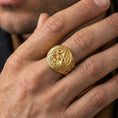 Load image into Gallery viewer, Gold plated all-seeing eye signet ring worn on a finger, close-up lifestyle image emphasizing the triangle eye emblem