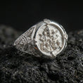 Load image into Gallery viewer, Polished silver Saint Peter Keys of Heaven signet ring with detailed Vatican key emblem and ornate sides, close-up on volcanic stone