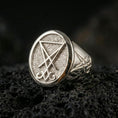 Load image into Gallery viewer, Polished silver Lucifer sigil signet ring featuring a bold raised emblem and clean beveled edges, close-up on volcanic stone