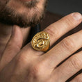 Load image into Gallery viewer, Gold plated finish sterling silver anchor and snake signet ring worn on a finger, close-up lifestyle photo emphasizing shine and maritime symbolism