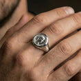 Load image into Gallery viewer, Polished silver finish Roman coin signet ring on the finger, macro lifestyle image focusing on the raised portrait seal and circular inscription