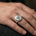 Load image into Gallery viewer, 925 sterling silver lion head signet ring worn on a finger, polished silver finish with clean highlights and round signet profile