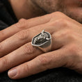 Load image into Gallery viewer, Oxidized bull signet ring worn on finger, lifestyle close-up focusing on the shield face and detailed horned head relief