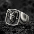 Load image into Gallery viewer, Oxidized sterling silver ram signet ring on volcanic rock, horned head shield face closeup