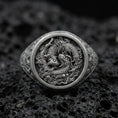 Load image into Gallery viewer, Oxidized sterling silver koi fish signet ring on textured volcanic rock, macro close-up showing detailed Japanese-inspired scales and swirling water relief