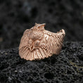 Load image into Gallery viewer, Rose gold plated owl ring on volcanic rock, sharp macro product photo showcasing the owl with outstretched wings and detailed feather pattern
