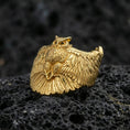 Load image into Gallery viewer, Gold plated owl ring on porous volcanic stone, premium dark studio shot emphasizing the owl body relief and layered wing feathers