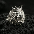 Load image into Gallery viewer, Polished silver lion king ring on volcanic rock surface, close-up highlighting sculpted facial features, layered mane texture, and crown detailing