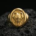 Load image into Gallery viewer, Gold plated elephant signet ring on porous volcanic stone, premium dark studio shot emphasizing the raised elephant relief and bold oval signet top