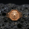 Load image into Gallery viewer, Rose gold plated lion head signet ring on porous volcanic rock, premium studio lighting and shallow depth