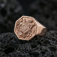Load image into Gallery viewer, Sterling silver Armenian coat of arms signet ring with a rose gold plated finish, bold heraldic signet ring featuring eagle and lion coat of arms, close-up on volcanic rock
