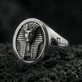 Load image into Gallery viewer, Sterling silver Egyptian pharaoh signet ring with an oxidized finish, oval face featuring a carved ancient king bust and side ankh symbol, macro on black volcanic rock