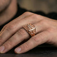 Load image into Gallery viewer, Sterling silver medieval lion signet ring on a finger, macro lifestyle shot featuring the rose gold plated finish and bold heraldic square face design