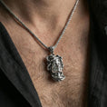 Load image into Gallery viewer, Polished silver Medusa head pendant necklace worn on the neck, clean lifestyle shot highlighting bright reflective details and sharp facial sculpting.