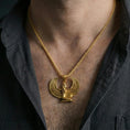 Load image into Gallery viewer, Gold plated winged goddess Isis pendant necklace worn on the neck, lifestyle photo featuring warm tone finish and strong statement pendant presence.