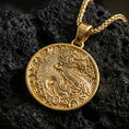 Load image into Gallery viewer, Gold plated dragon medallion pendant necklace on textured volcanic rock, premium close-up with warm reflective shine across the dragon head, flowing mane, and raised border.