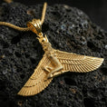 Load image into Gallery viewer, Gold plated winged goddess ankh pendant necklace on textured volcanic rock, premium close-up with warm reflective shine across the wings, goddess figure, and engraved textures.