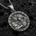 Load image into Gallery viewer, Oxidized Odin and raven medallion pendant necklace on textured volcanic rock, centered close-up highlighting the Viking warrior relief, spear detail, and deep antique shadowed contrast.