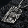 Load image into Gallery viewer, Oxidized Hel Norse goddess pendant necklace on textured volcanic rock, centered close-up highlighting the half-skull face, raven detail, rune accents, and deep antique shadowed contrast.