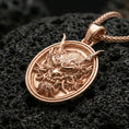 Load image into Gallery viewer, Rose gold plated demon mask medallion pendant necklace on textured volcanic rock, centered studio-style close-up showcasing soft rosy glow and intricate mask-and-fang detailing with a refined finish.