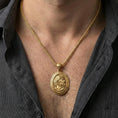 Load image into Gallery viewer, Gold plated Hades coin pendant necklace worn on the neck, lifestyle photo featuring warm tone finish and strong statement medallion presence.