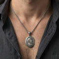 Load image into Gallery viewer, Oxidized Hades coin pendant necklace worn on the neck, lifestyle framing showing realistic scale and bold vintage contrast against the chest.